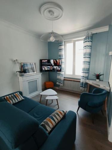 un salon avec un canapé bleu et des chaises dans l'établissement Maison Amiénoise avec terrasse et jardinet, à Amiens
