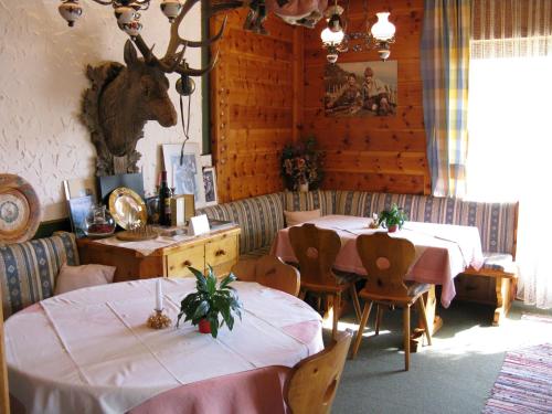 a dining room with two tables and a cow head on the wall at Landgasthof Hubertusstubn in Sankt Michael im Lungau