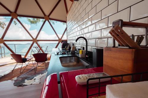 a kitchen with a sink and a large window at NOMADPLACE in São Bento do Sapucaí