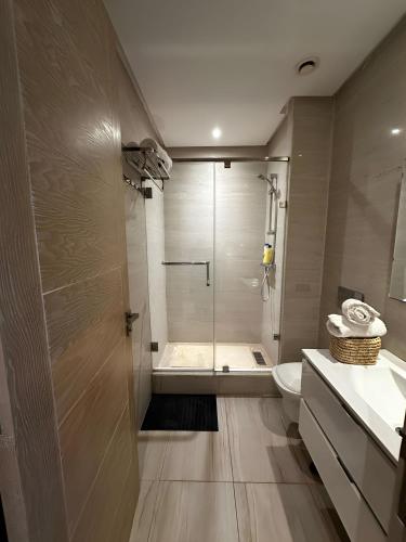 a bathroom with a shower and a toilet and a sink at Appartement de luxe en bord de mer avec piscine in Mansouria