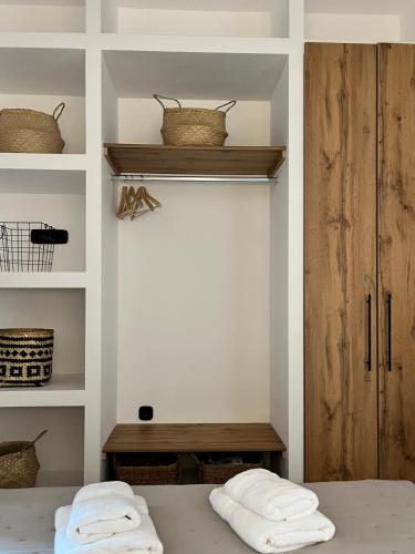 a bedroom with white walls and shelves with towels at Casa Stergia - Village Project in Psinthos