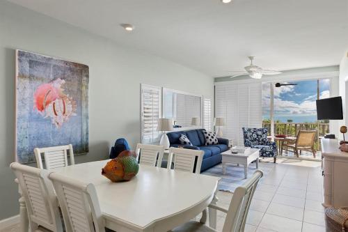 サニベルにあるExquisite Beachfront Residence at Shell Island Beach Club of Sanibelの白いテーブルと椅子のあるリビングルーム