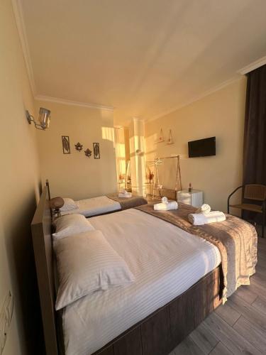 a bedroom with two twin beds with white sheets at WoodSea in Batumi