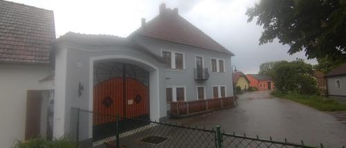 una casa blanca con una puerta grande en una calle en Weingut Brandl, en Strass