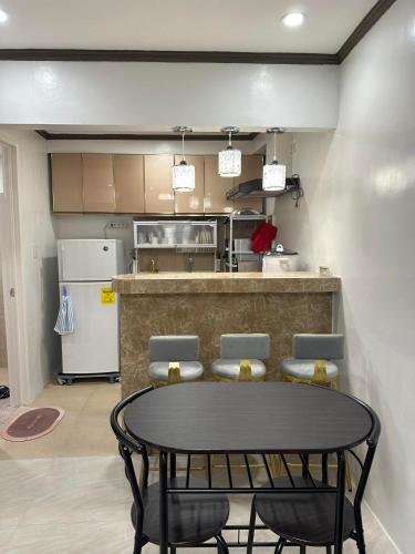 a kitchen with a table and some chairs and a counter at Windmill Chimes in Rizal