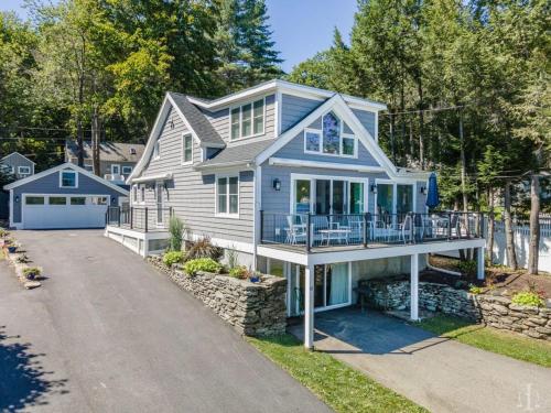 a white house with a porch and a driveway at Beautiful Home 30 Feet from the Sand at Spofford Lake! in Chesterfield