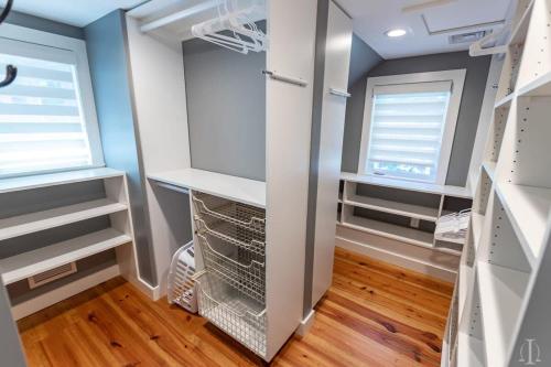 a walk in closet with two windows in a room at Beautiful Home 30 Feet from the Sand at Spofford Lake! in Chesterfield