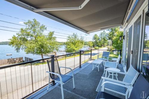 a balcony with chairs and a view of the water at Beautiful Home 30 Feet from the Sand at Spofford Lake! in Chesterfield