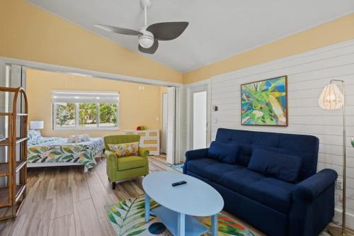 a living room with a blue couch and a table at Renovated Cottage at the Historic Palms Inn of Sanibel- Includes Pool and Bikes in Sanibel