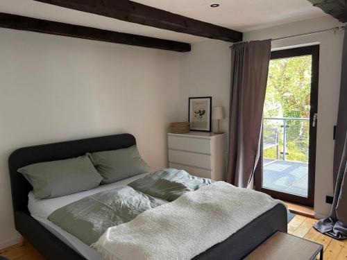 1 dormitorio con cama y ventana grande en Traumschönes Fachwerk in Hamelns Altstadt, en Hameln