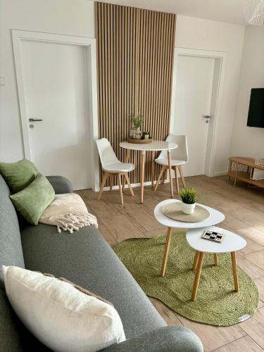 a living room with a gray couch and tables at Home & Apart - Apartment im Herzen von Kreyenbrück - Apartment 1 in Oldenburg