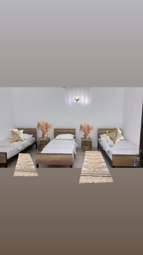 a room with three beds and two tables at Hostel,halal in Tokmok