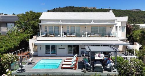 a house with a swimming pool in front of it at Lasalle holiday home (Sun, Beach, Views, Fun for everyone!) in Plettenberg Bay