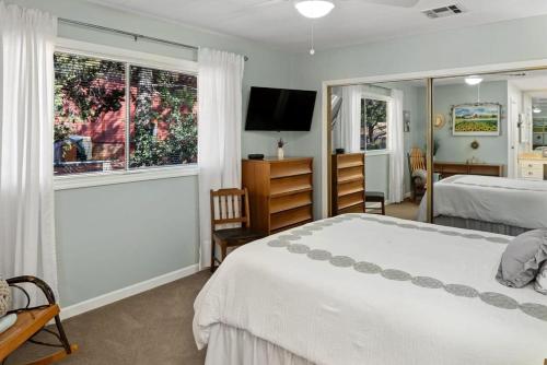 a bedroom with two beds and a flat screen tv at Gorgeous West Sedona Home with Red Rock Views in Sedona