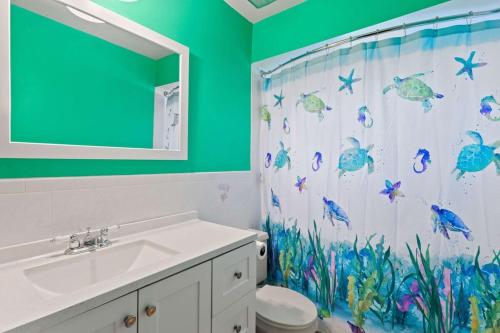 a bathroom with a shower curtain with fish on it at Cute Coastal Home with Pool in Fort Myers