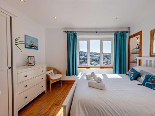 una camera da letto con un grande letto bianco con tende blu di 3 bed in Brixham BX038 a Brixham