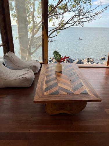 a wooden table in a room with a view of the ocean at El Pital, Chocolate Paradise in Balgue