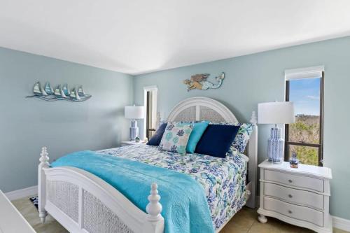 a blue bedroom with a white bed and a window at Stunning Waterfront Residence with Panoramic Water Views in Fort Myers