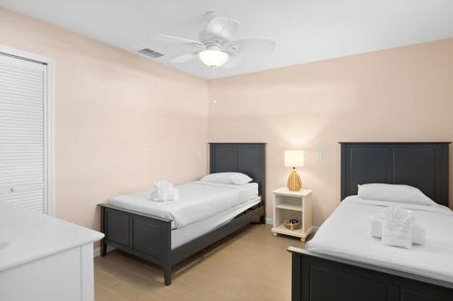 a bedroom with two beds and a ceiling fan at Gorgeous Apartment on Mango St Steps to Beach in Fort Myers Beach