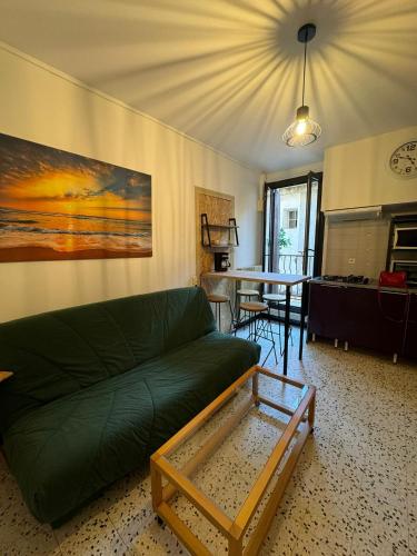 un salon avec un canapé vert et une table dans l'établissement Duo Mario Roustan, à Sète