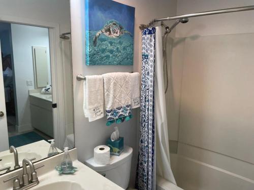 a bathroom with a sink and a toilet and a mirror at Gorgeous 3 Bedroom Home in the Dunes Sleeps 8 in Sanibel