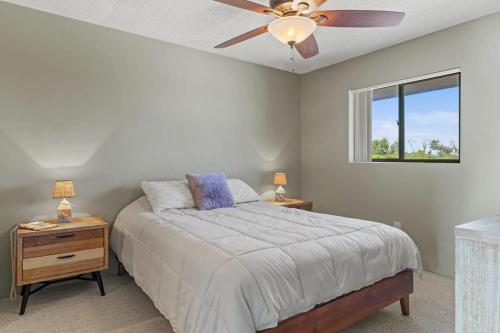 a bedroom with a bed and a ceiling fan at Comfy Waterfront Condo at Tennisplace Sanibel in Sanibel