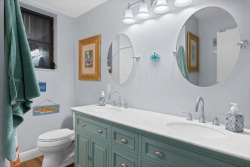 a bathroom with a sink and a toilet and a mirror at Colonel's Cottage- Sanibel Beach Retreat Fantastic Amenities in Sanibel