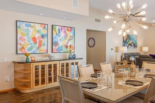 a dining room with a table and chairs and a chandelier at Serenity Palms- Gorgeous Villa in Palm Springs in Palm Springs