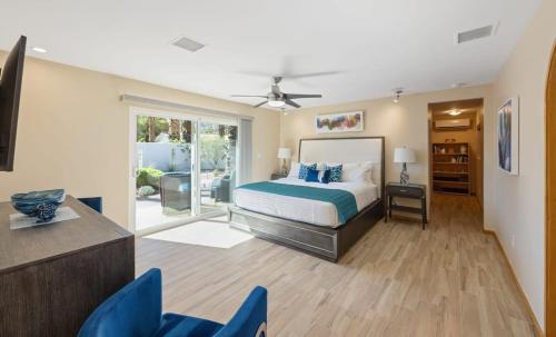 a bedroom with a bed and a table and chairs at Serenity Palms- Gorgeous Villa in Palm Springs in Palm Springs