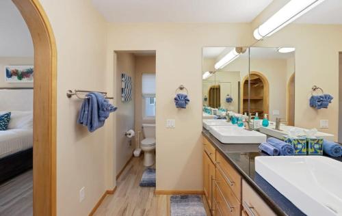 a bathroom with three sinks and a large mirror at Serenity Palms- Gorgeous Villa in Palm Springs in Palm Springs