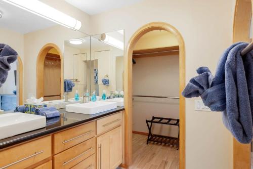 a bathroom with two sinks and a large mirror at Serenity Palms- Gorgeous Villa in Palm Springs in Palm Springs