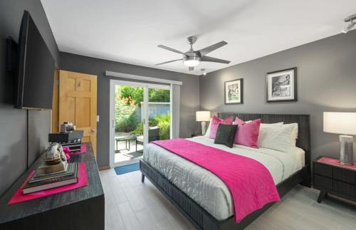 a bedroom with a large bed with a pink blanket at Serenity Palms- Gorgeous Villa in Palm Springs in Palm Springs