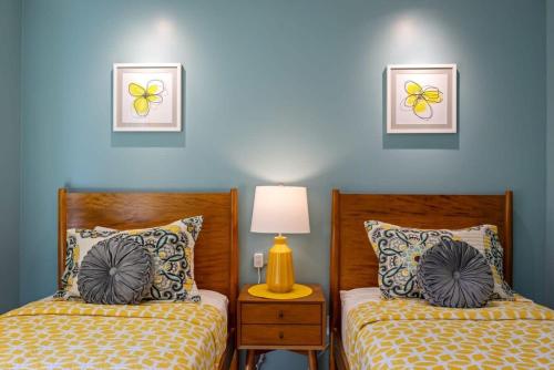 two beds in a bedroom with blue walls at Serenity Palms- Gorgeous Villa in Palm Springs in Palm Springs