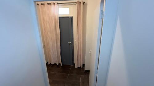 a hallway with a black door and a window at Gabiro in Bondy