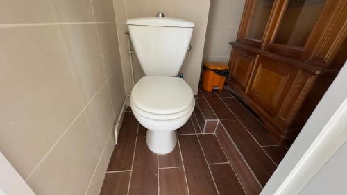 a white toilet in a bathroom with a wooden door at Gabiro in Bondy