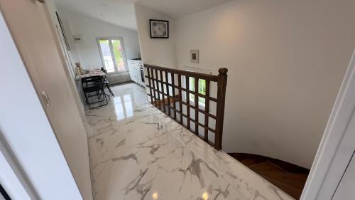 a hallway with a marble floor and a staircase at Gabiro in Bondy