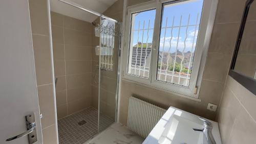 baño con ducha, lavabo y ventana en Gabiro, en Bondy
