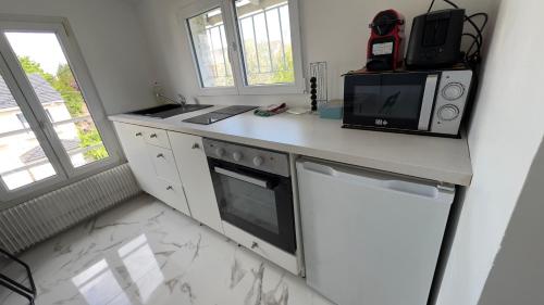 a kitchen with a microwave and a stove top oven at Gabiro in Bondy