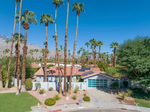 a house with palm trees in front of it at Serenity Palms- Gorgeous Villa in Palm Springs in Palm Springs