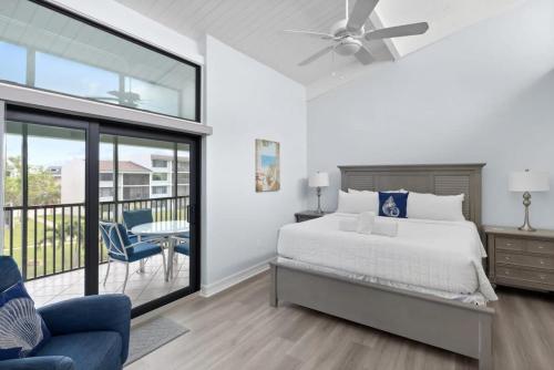 ein Schlafzimmer mit einem Bett und einem Balkon in der Unterkunft Loggerhead 253- Beachfront Residence w Vaulted Ceilings in Sanibel