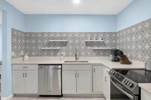 a kitchen with white cabinets and a sink at Stunning Newly Renovated River District Residence in Fort Myers