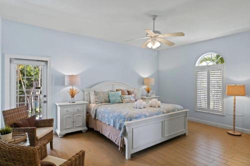 a bedroom with a bed and a ceiling fan at Mango Margarita- Beach Home with Pool Sleeps 12 in Fort Myers Beach