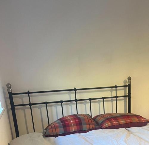 Una cama con dos almohadas encima. en double room, en New Barnet