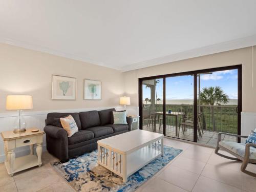 a living room with a couch and a table at South Seas Beach Villa 2426 - Stunning Beachfront Residence in Captiva
