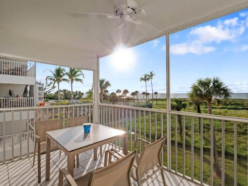 a balcony with a table and chairs and a view of the ocean at South Seas Beach Villa 2426 - Stunning Beachfront Residence in Captiva