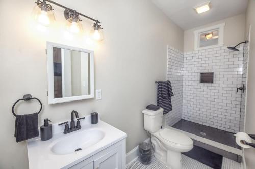 a white bathroom with a sink and a toilet at Charming Condo in Historic Downtown Building in Wilmington