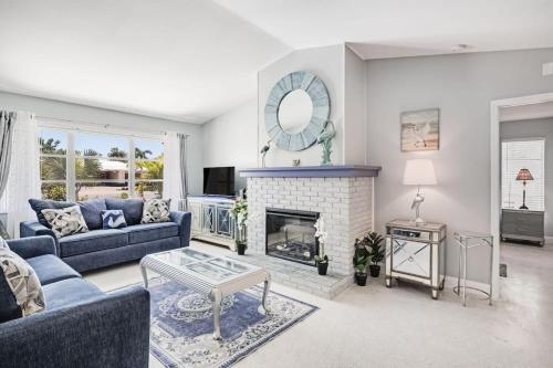 Una sala de estar con un sofá azul y una chimenea. en Gorgeous Pool Home in Lake Murex Sanibel, en Sanibel