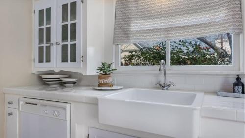 a white kitchen with a sink and a window at Chocolate Diamond private hot tub walk to Main in Fredericksburg