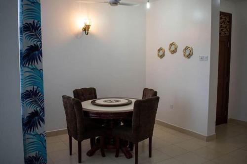 uma sala de jantar com uma mesa e quatro cadeiras em Modern 1bedroom 5 min walk to the beach near Severine Neptune beach resort behind go kart em Mombasa