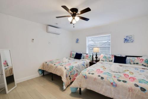 a bedroom with two beds and a ceiling fan at Gorgeous Beach Condo with Pool Spa and Bikes in Fort Myers Beach